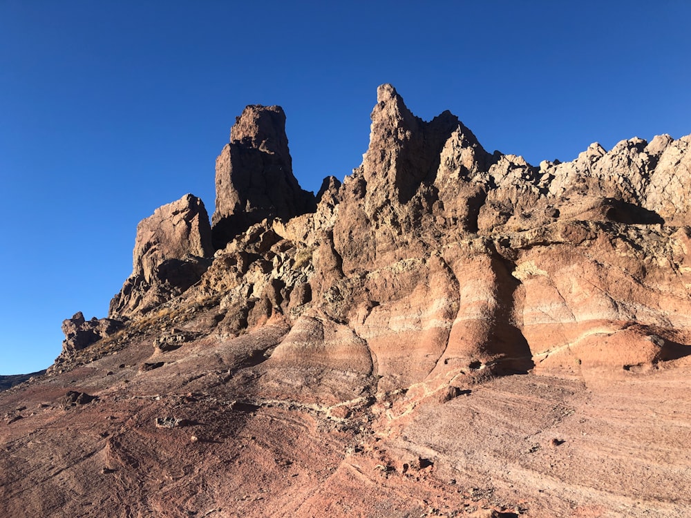 a rocky mountain with a blue sky in the background