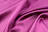 Close-up of an elegant royal pink silk saree shimmering under soft light.