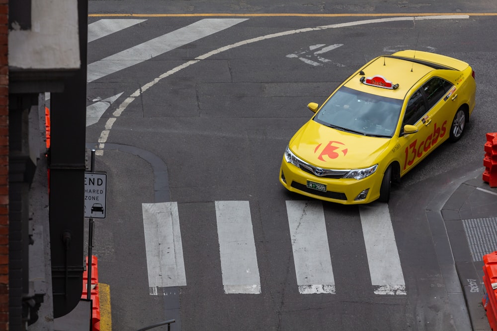 a yellow taxi cab driving down a street