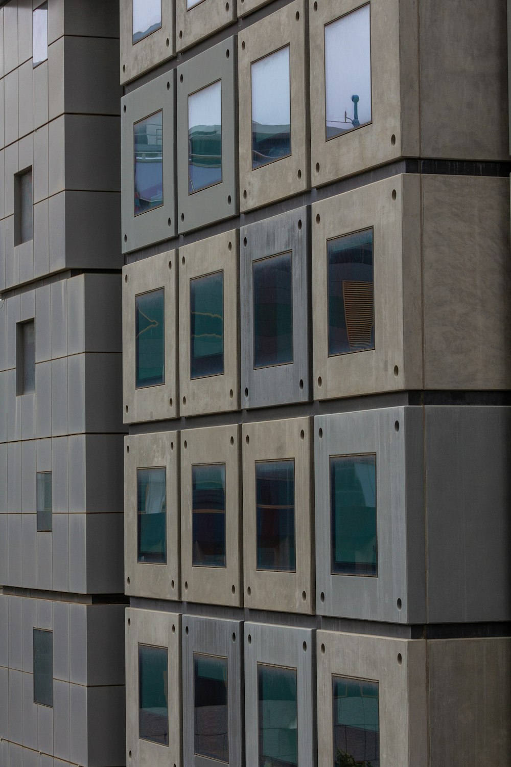 a tall building with lots of windows next to a parking meter