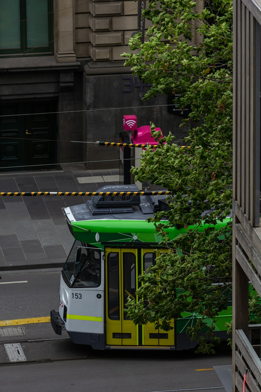 a green and yellow bus driving down a street
