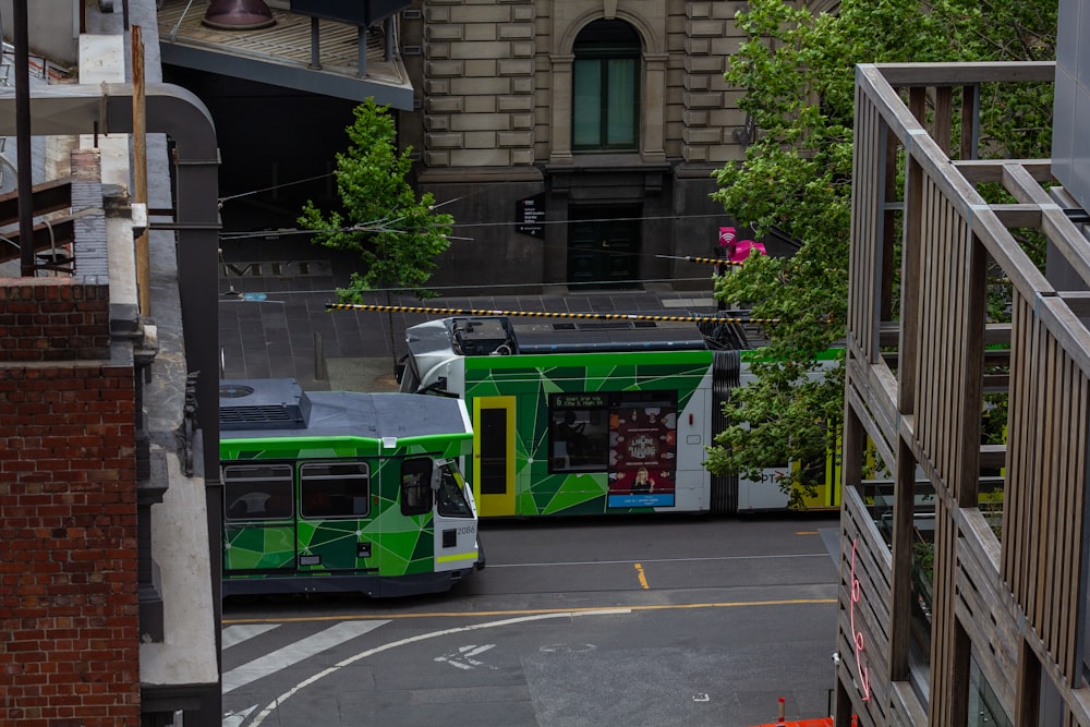 a couple of green buses parked next to each other