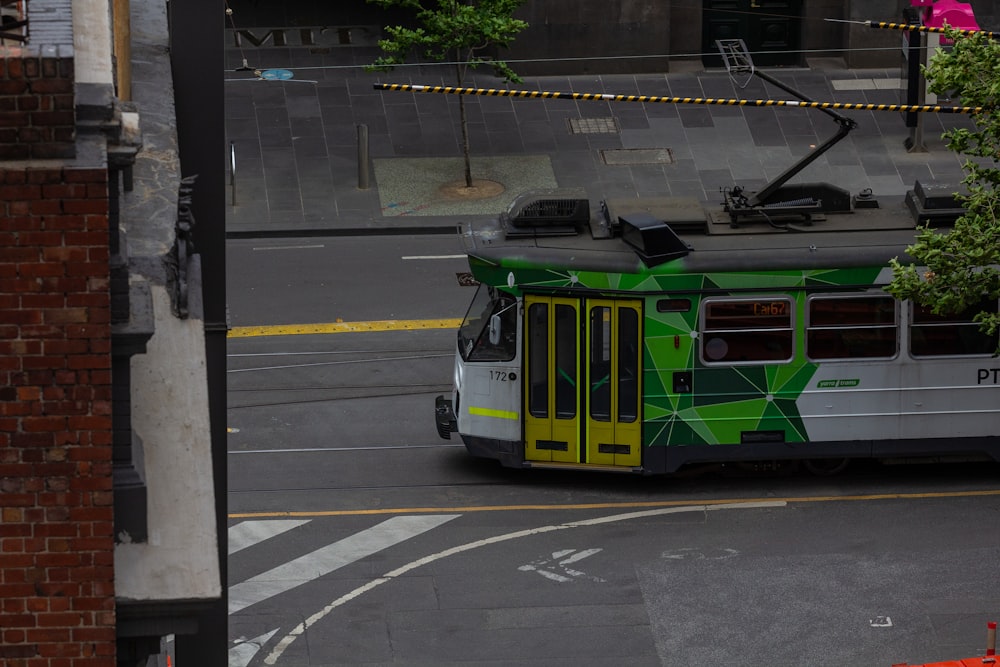a green and white trolley on a city street