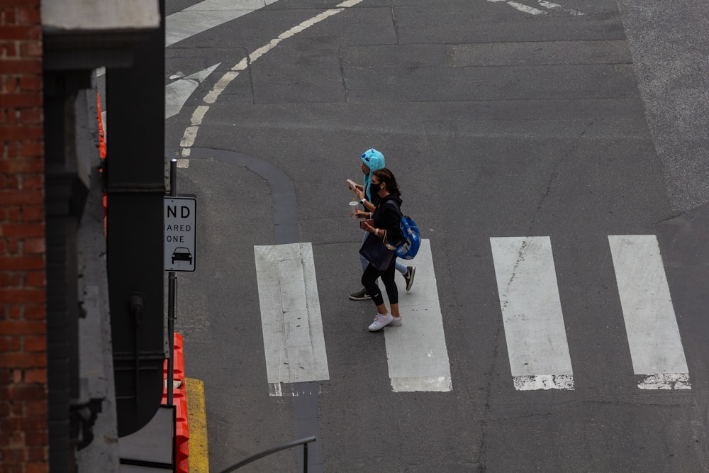 a couple of people walking across a street