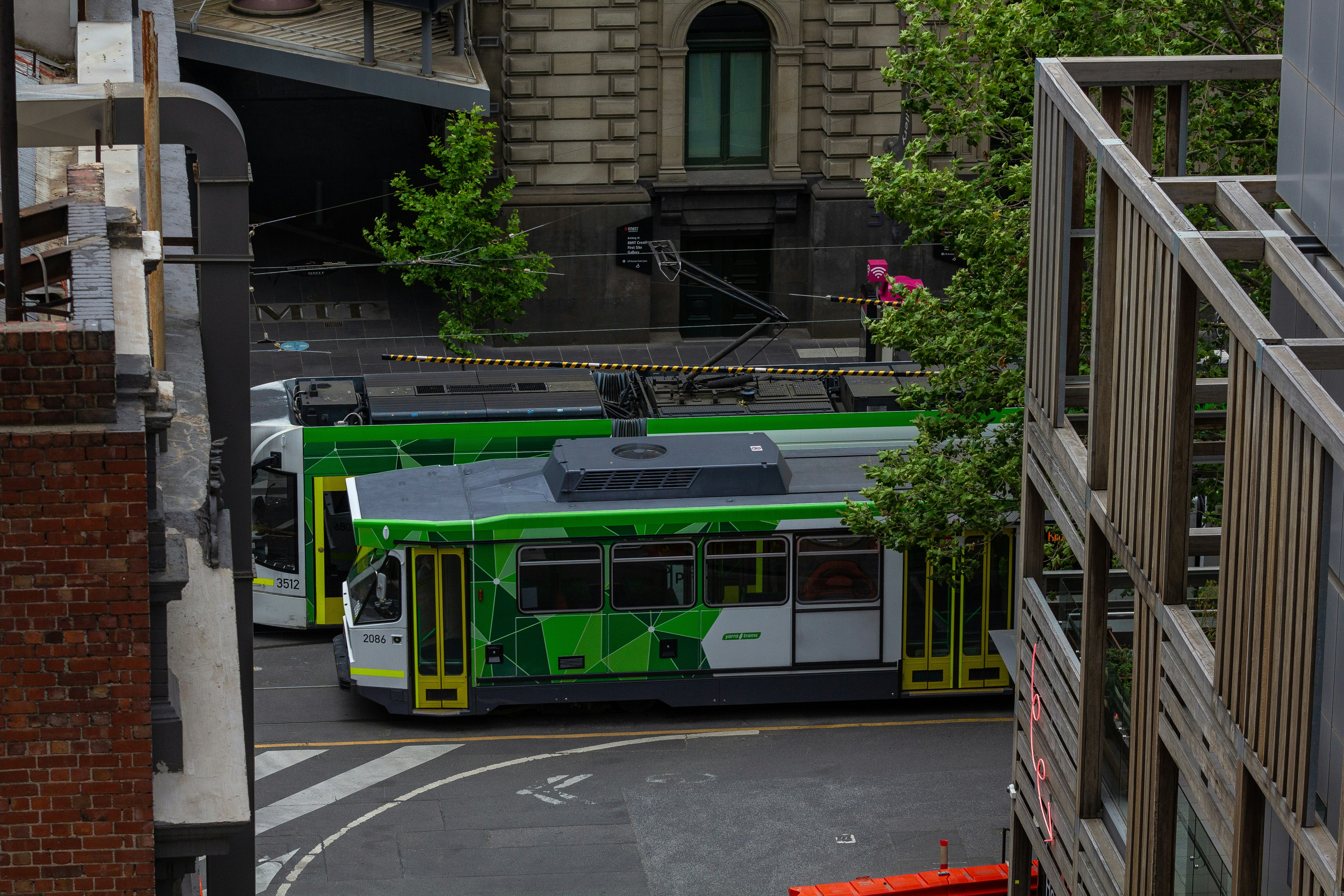 a green and white bus driving down a street