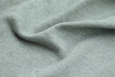 Close-up of a soft linen blouse dyed in layered shades of warm ochre and deep green.