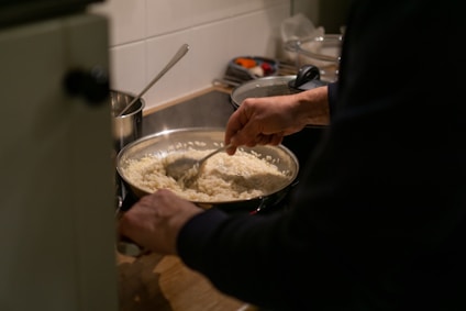 a person stirring a bowl of food on a stove