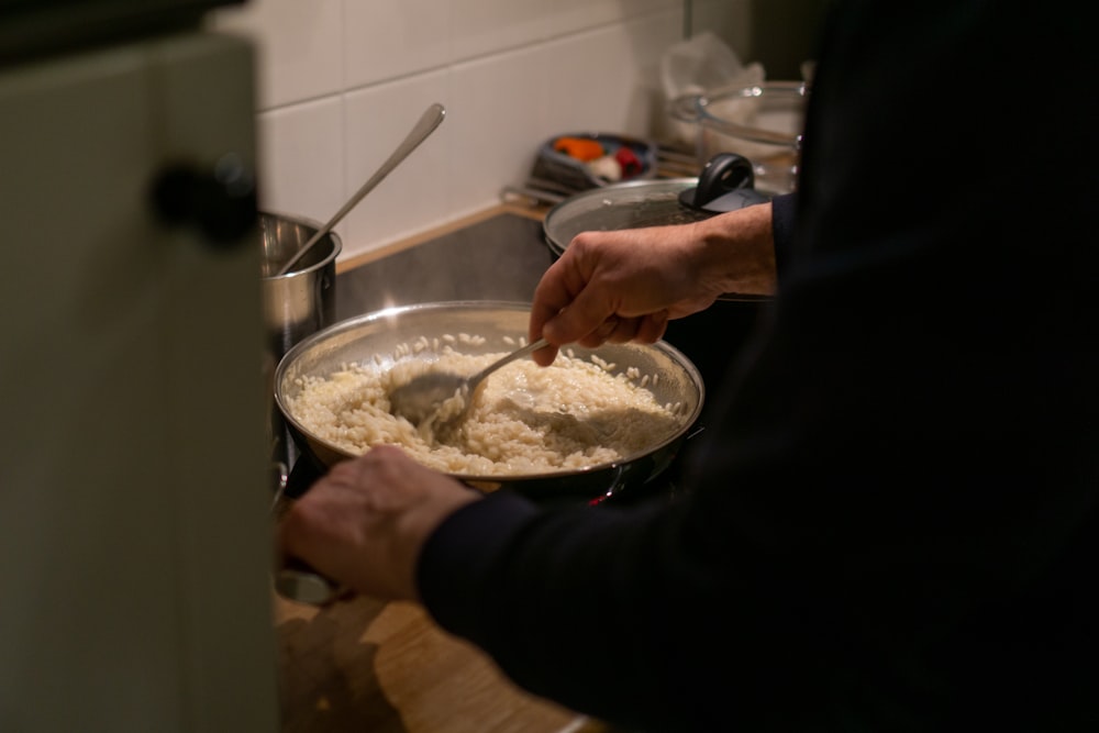 a person stirring a bowl of food on a stove