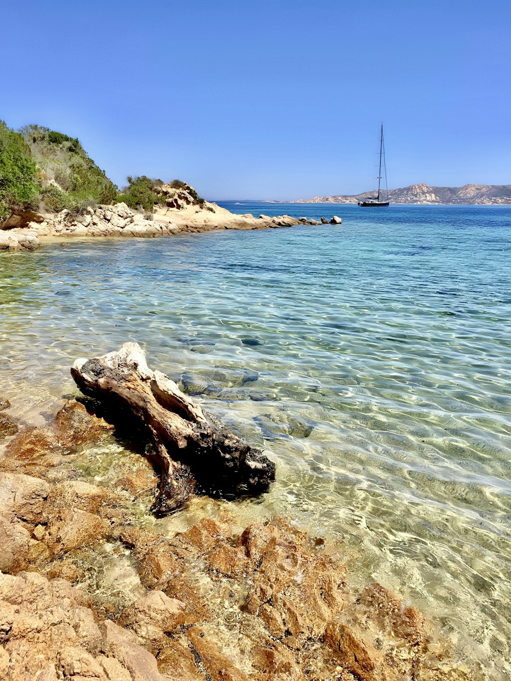 a boat is in the water near a rocky shore