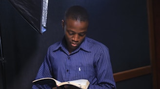 a man reading a book in a dark room
