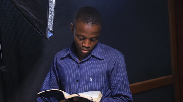 a man reading a book in a dark room