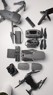 Array of drone parts laid out neatly on a black mat, showcasing motors, propellers, and frames