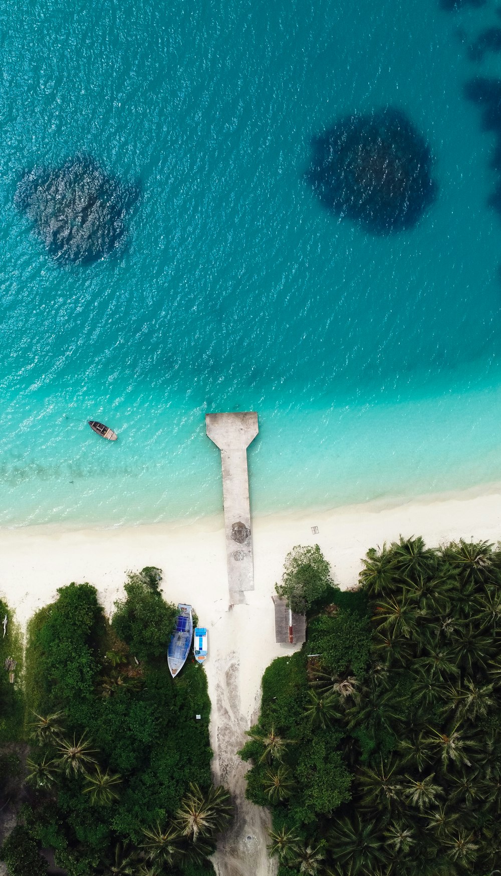 Una vista aérea de una playa con un barco en el agua