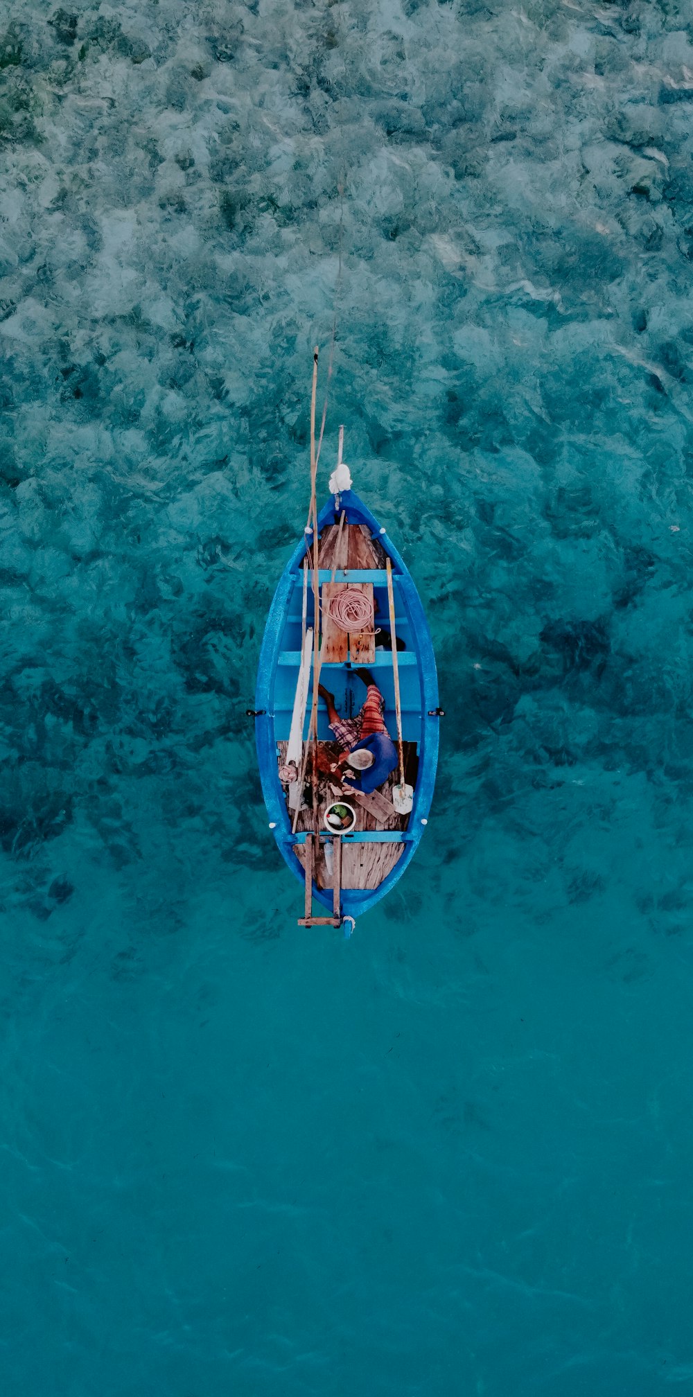 a small blue boat floating on top of a body of water