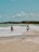 a couple of men standing on top of a sandy beach