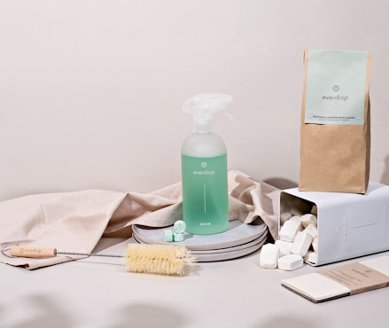 a white table with a bottle of soap, a brush, and other items