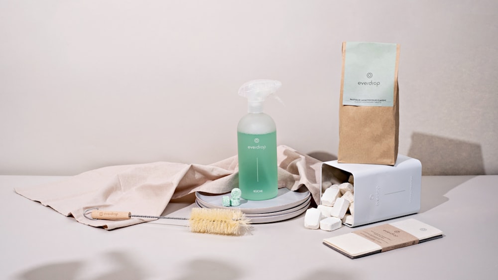 a white table with a bottle of soap, a brush, and other items