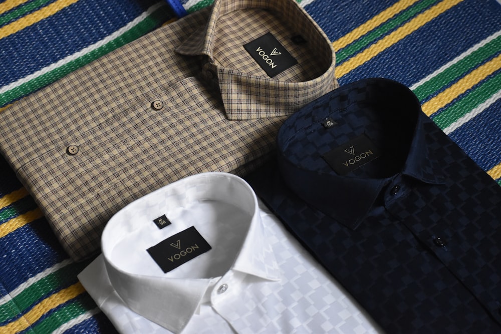 a variety of men's shirts laid out on a bed