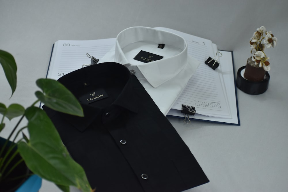 a white shirt and a black shirt on a table