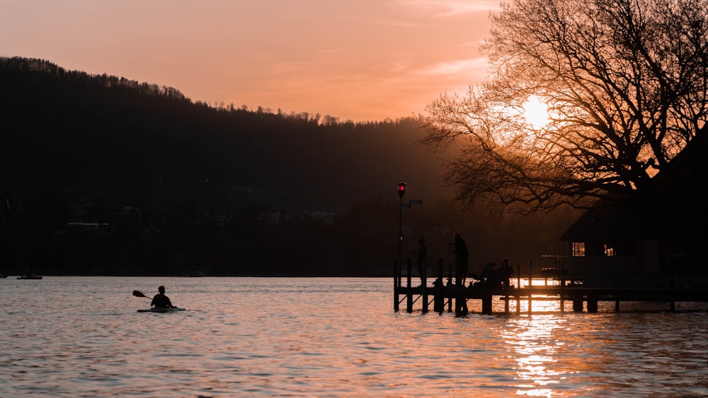 a person in a kayak on a lake at sunset