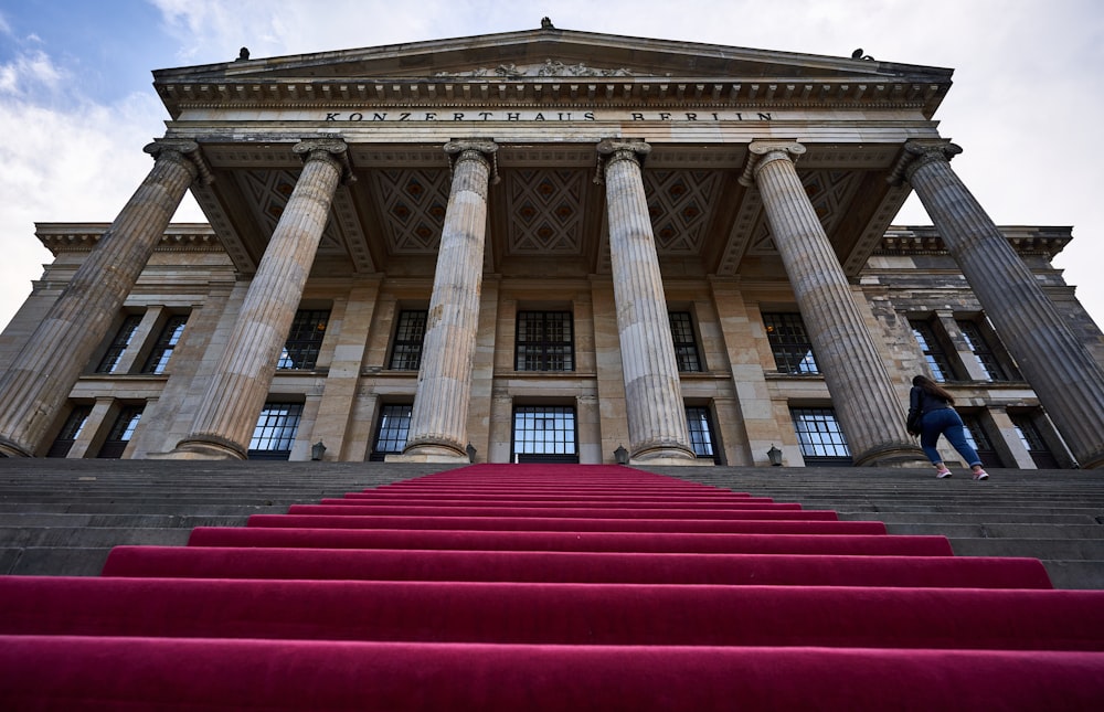 a man walking up a set of stairs in front of a building