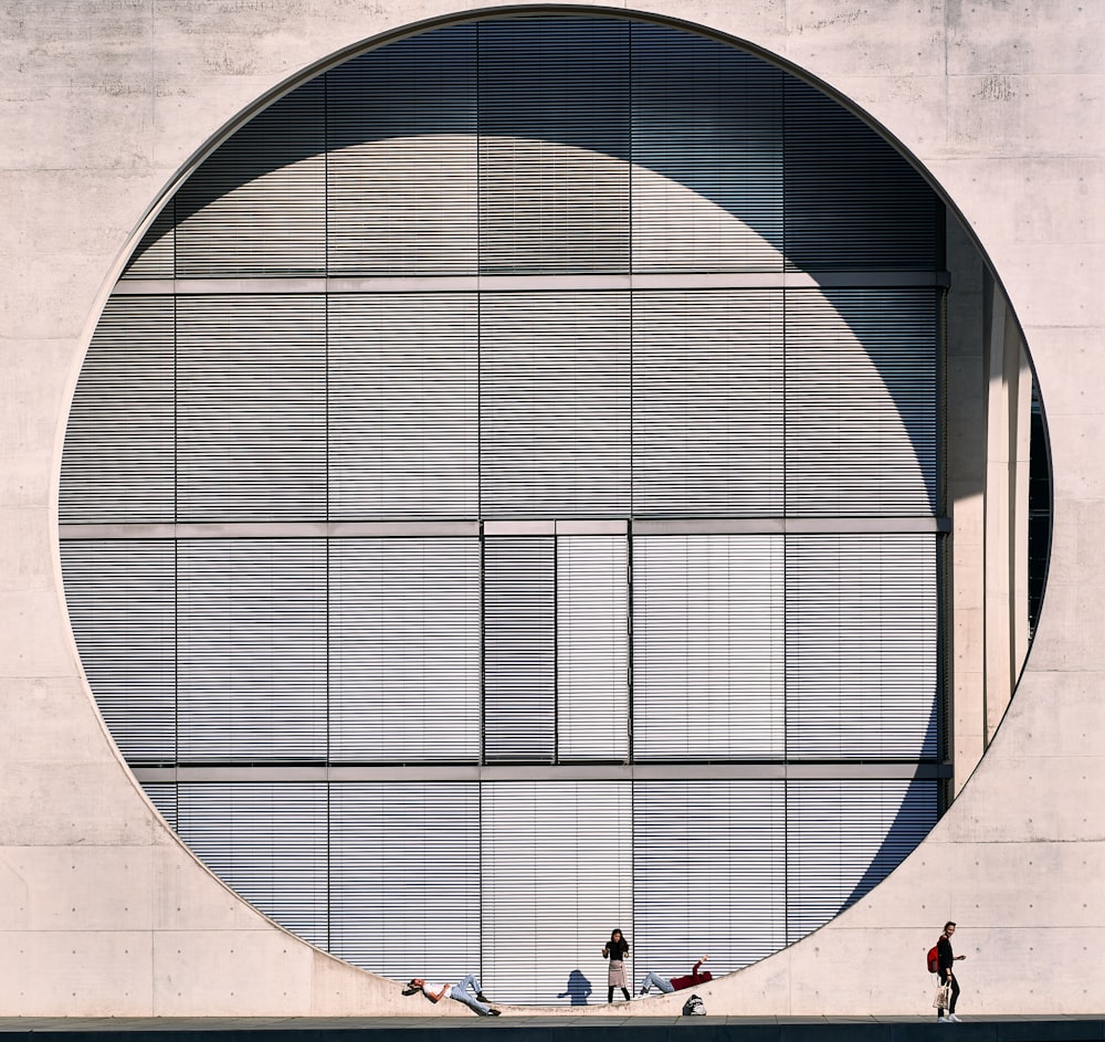 people walking on a sidewalk in front of a building