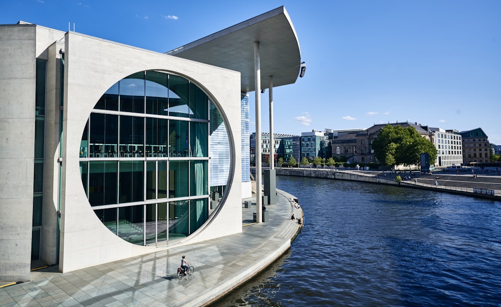 a building with a circular window next to a body of water