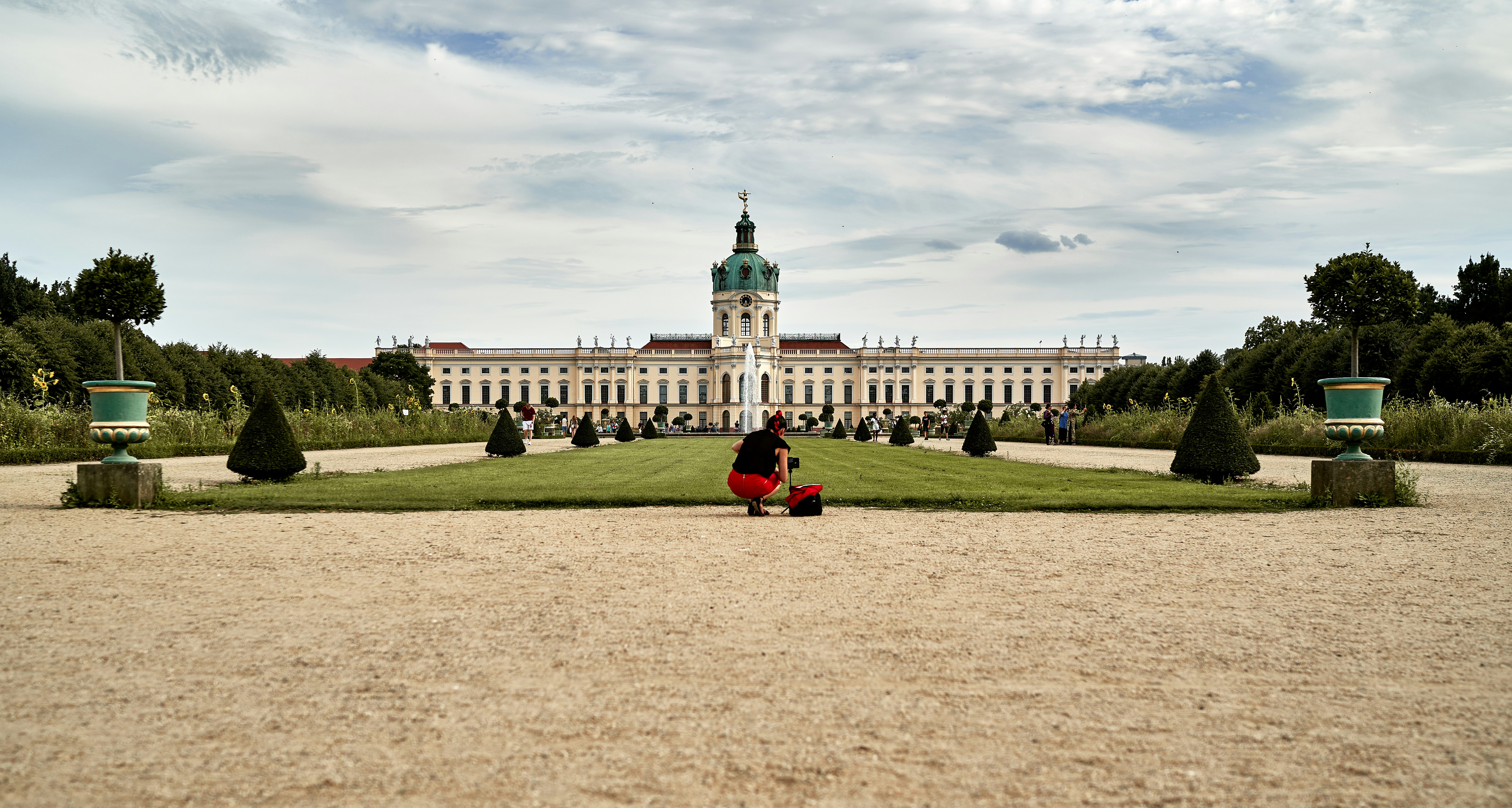 a person sitting on a bench in front of a large building