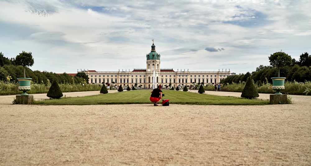 a person sitting on a bench in front of a large building