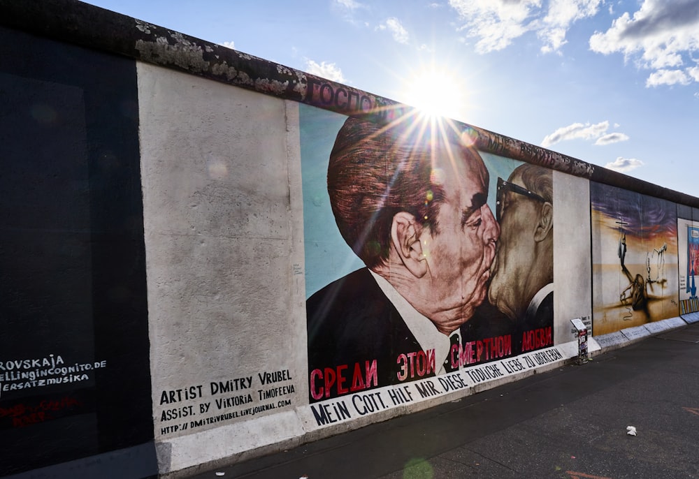 um mural de um homem beijando uma mulher ao lado de um edifício