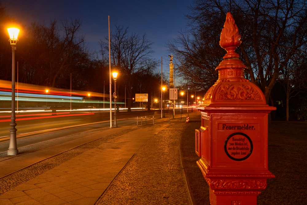 a red fire hydrant sitting on the side of a road