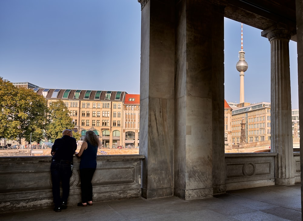 a man and a woman are standing on a balcony