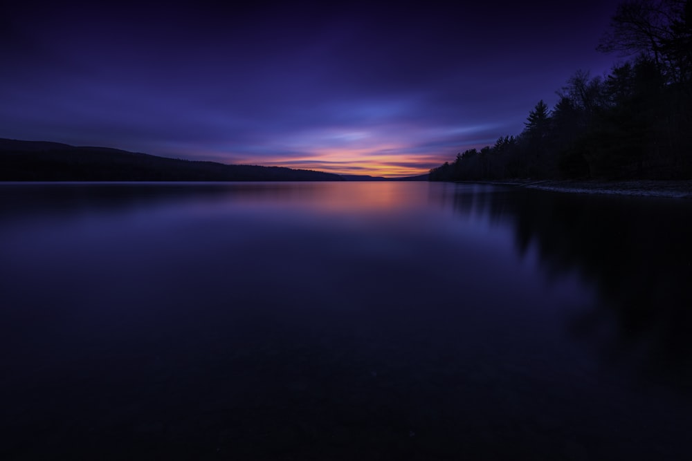 a lake with a sunset in the background