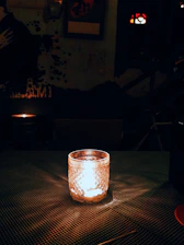 A cozy, softly lit room featuring a handcrafted Velora candle on a wooden table surrounded by natural decor.