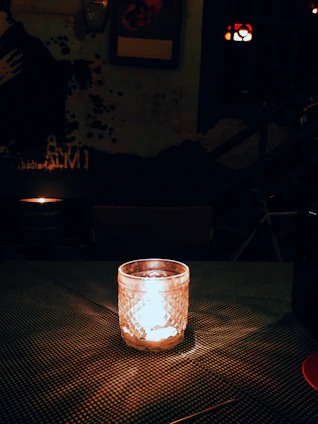 A cozy, softly lit room featuring a handcrafted Velora candle on a wooden table surrounded by natural decor.
