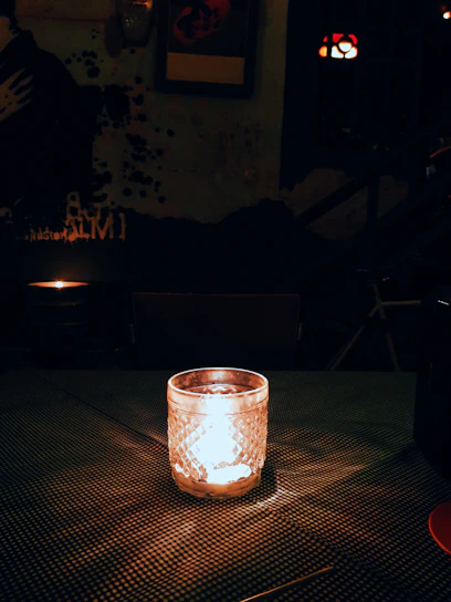 A softly lit room featuring a minimalist candle on a wooden table, surrounded by subtle home decor accents.