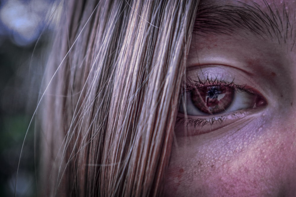 a close up of a person's face with a bloody eye