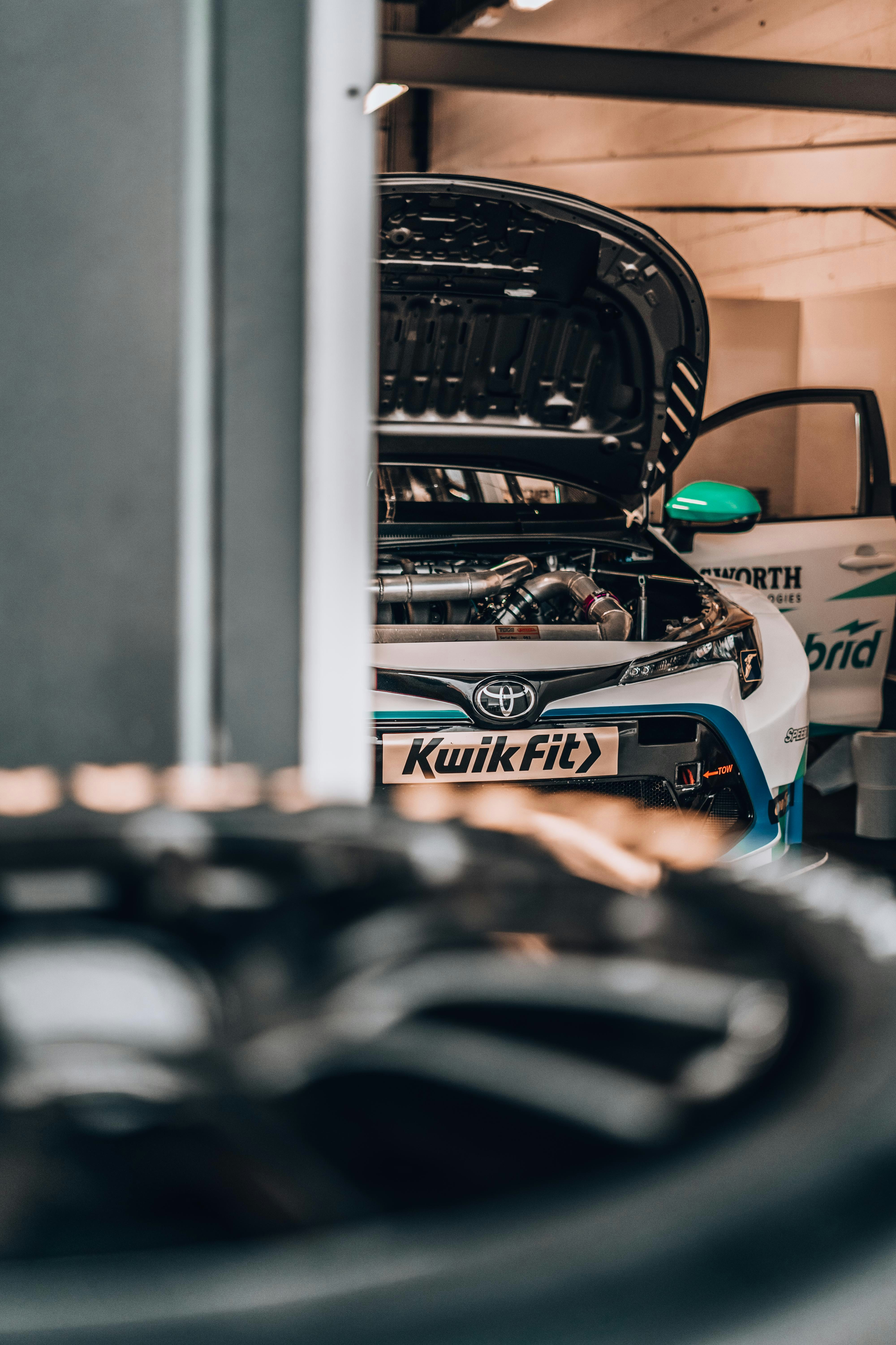 white Toyota touring car racing car parked in garage during daytime
