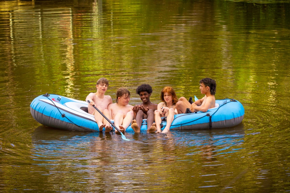 Un gruppo di persone che cavalcano sulla cima di una zattera nell'acqua