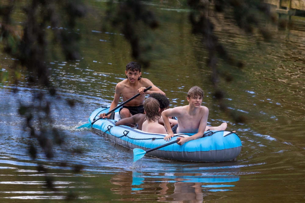 a group of young men riding on top of a blue raft