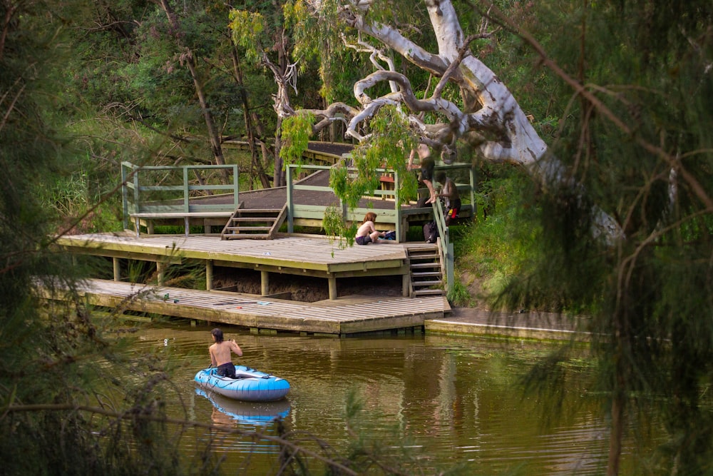 a man in a blue raft floating on top of a lake