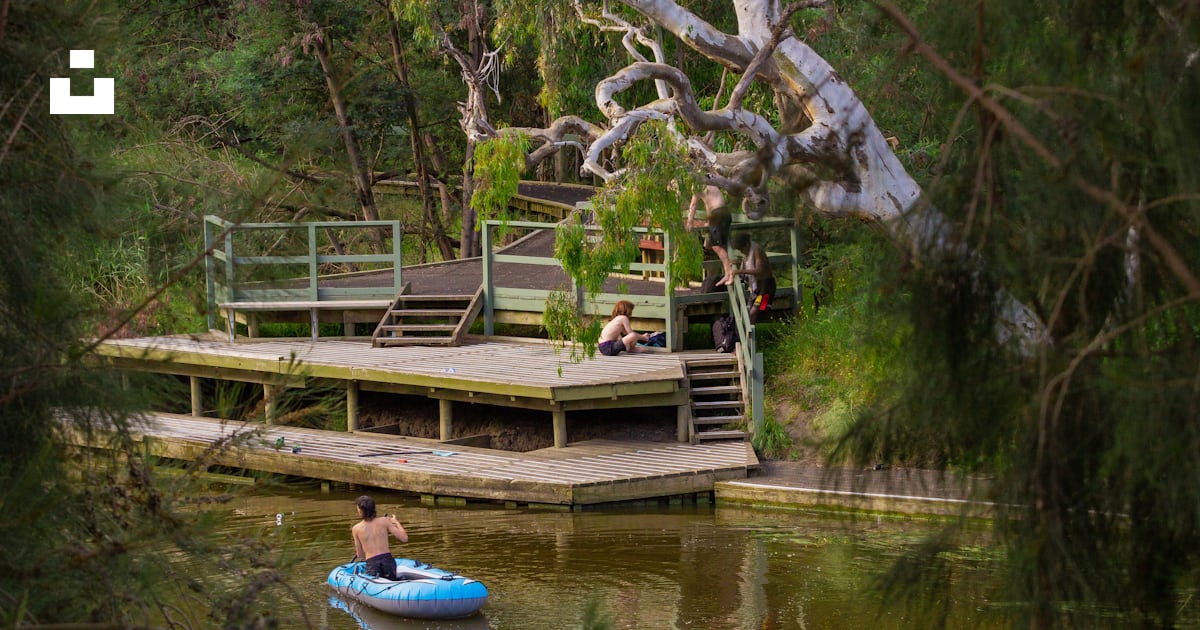 A man in a blue raft floating on top of a lake photo – Free Yollinko ...