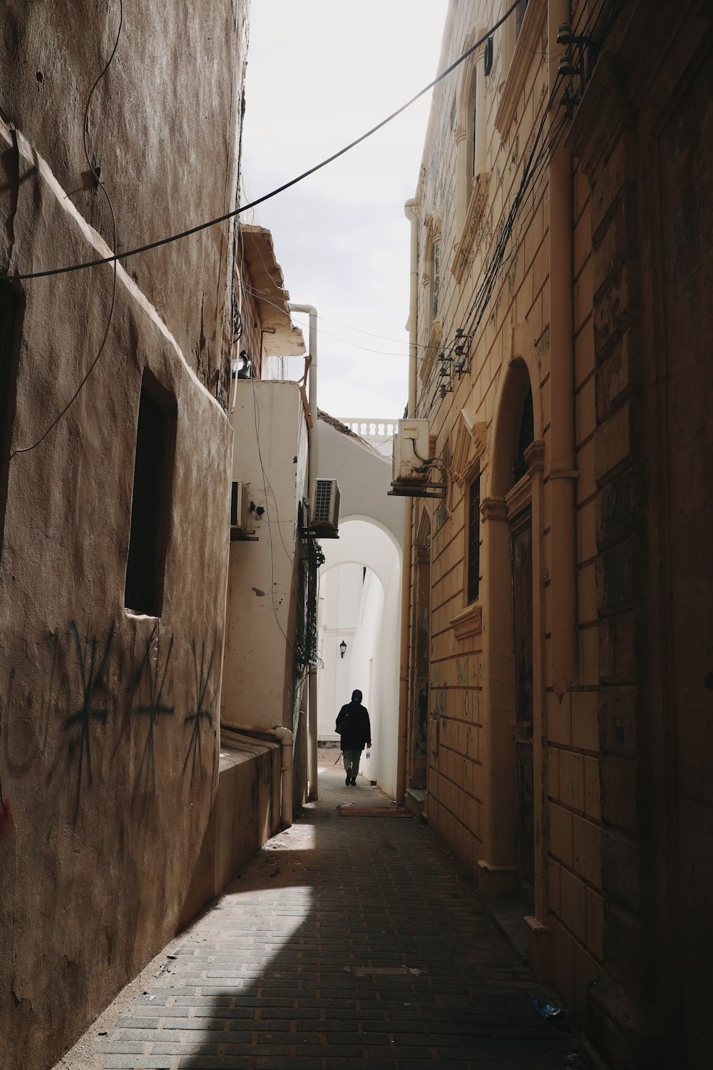 a man walking down a narrow alley way