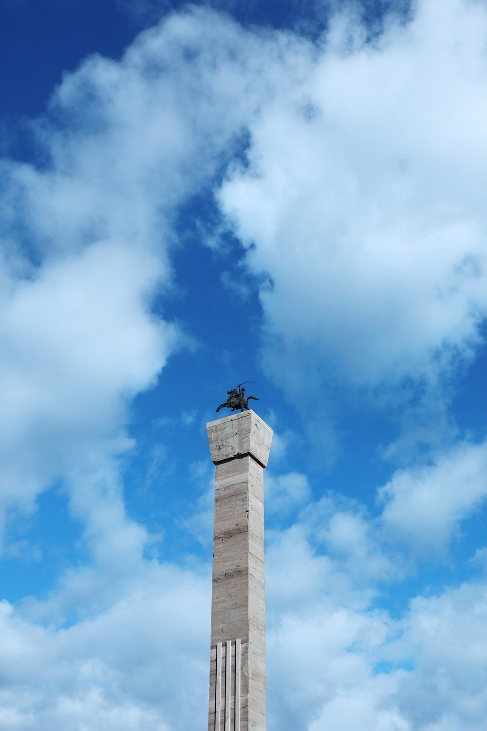 un grand monument avec un oiseau assis dessus