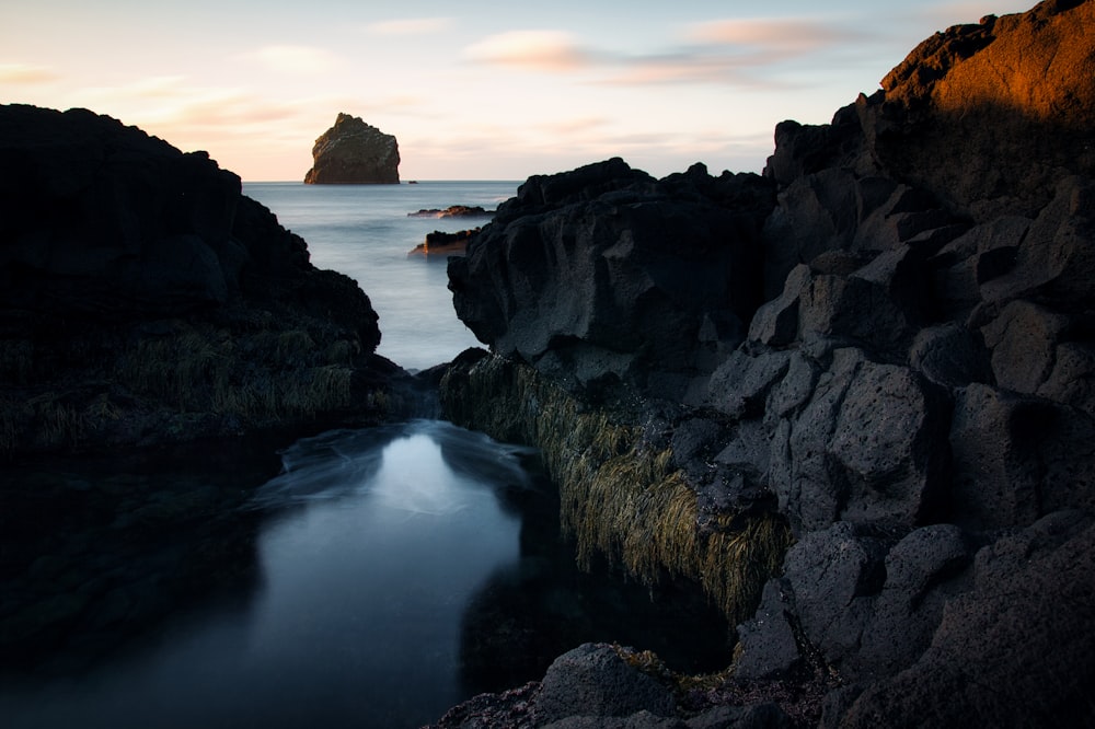 a rocky island in the middle of a body of water