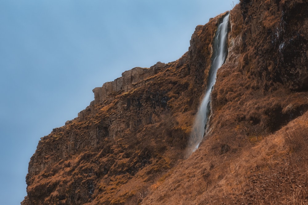 a waterfall is coming down the side of a mountain