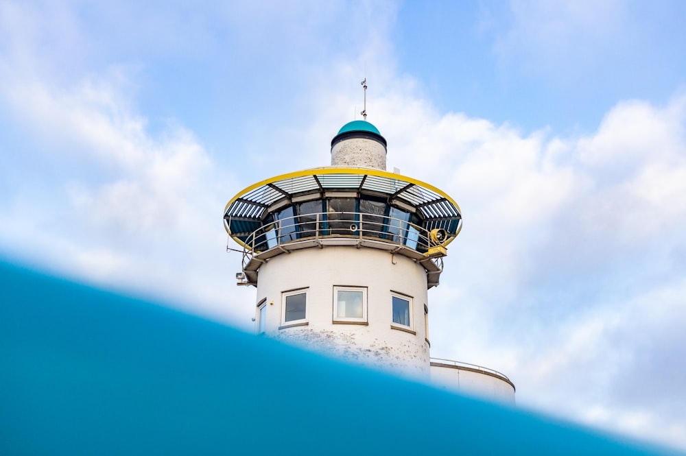 a white lighthouse with a blue sky in the background