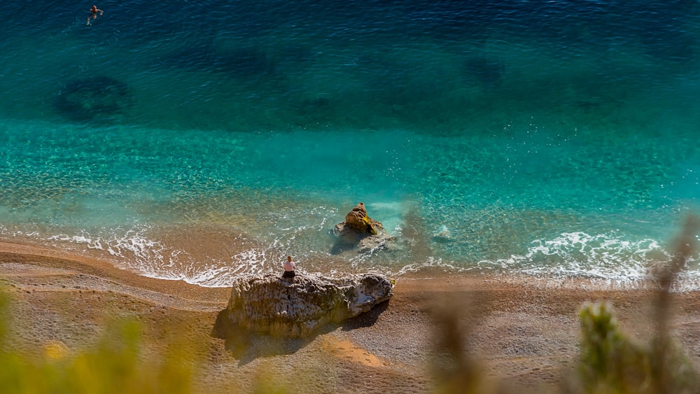 two people are swimming in the clear blue water