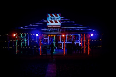 a man standing in front of a building covered in christmas lights
