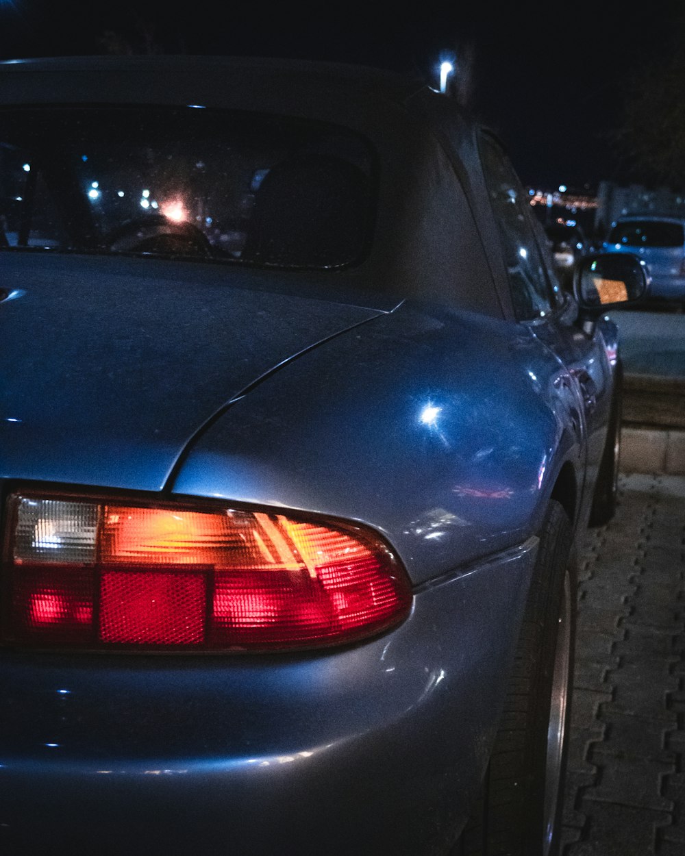 a car parked on the side of the road at night